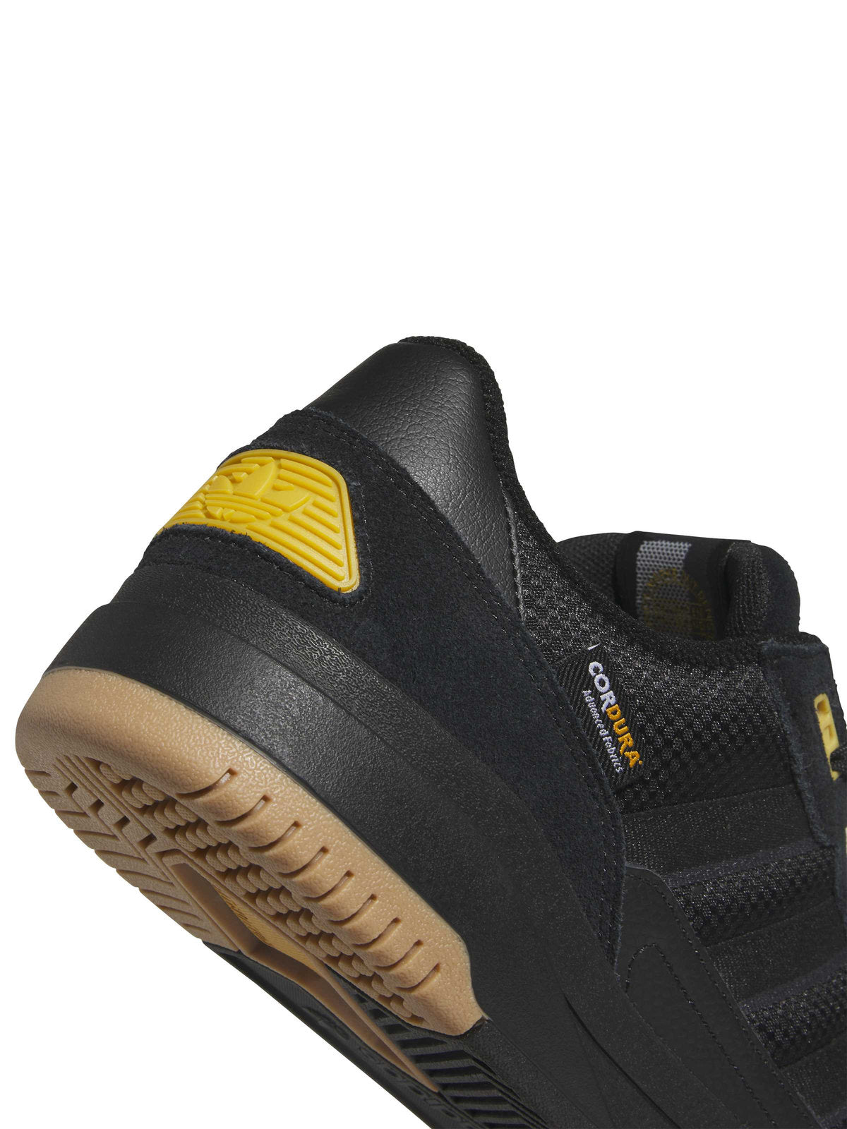 Chaussures de skateboard Adidas Tekkira Cup Black Carbon Core Black, gros plan sur le talon, l'étiquette Cordura, le patch jaune et la semelle gum