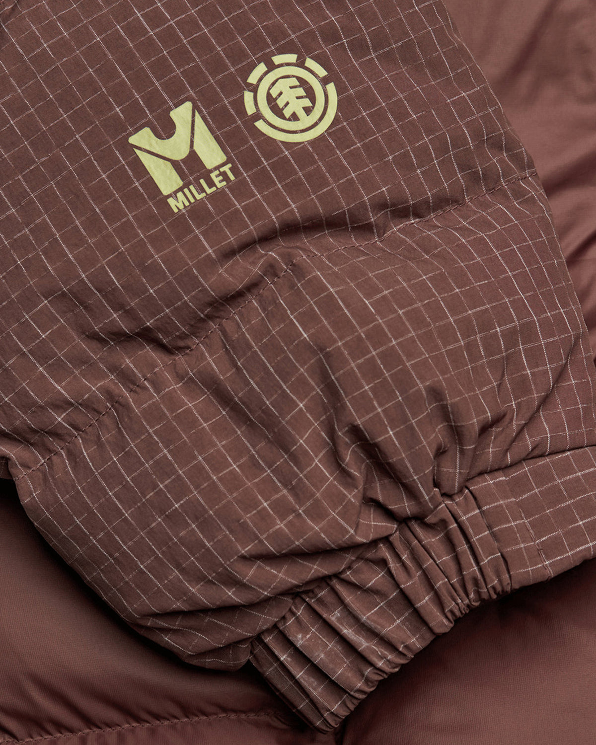 Vestes Element Mxe Puff Down J (N353) Truffle Mxe, gros plan sur le poignet élastique à motif ripstop, imprimé des logos Millet et Element côte à côte.
