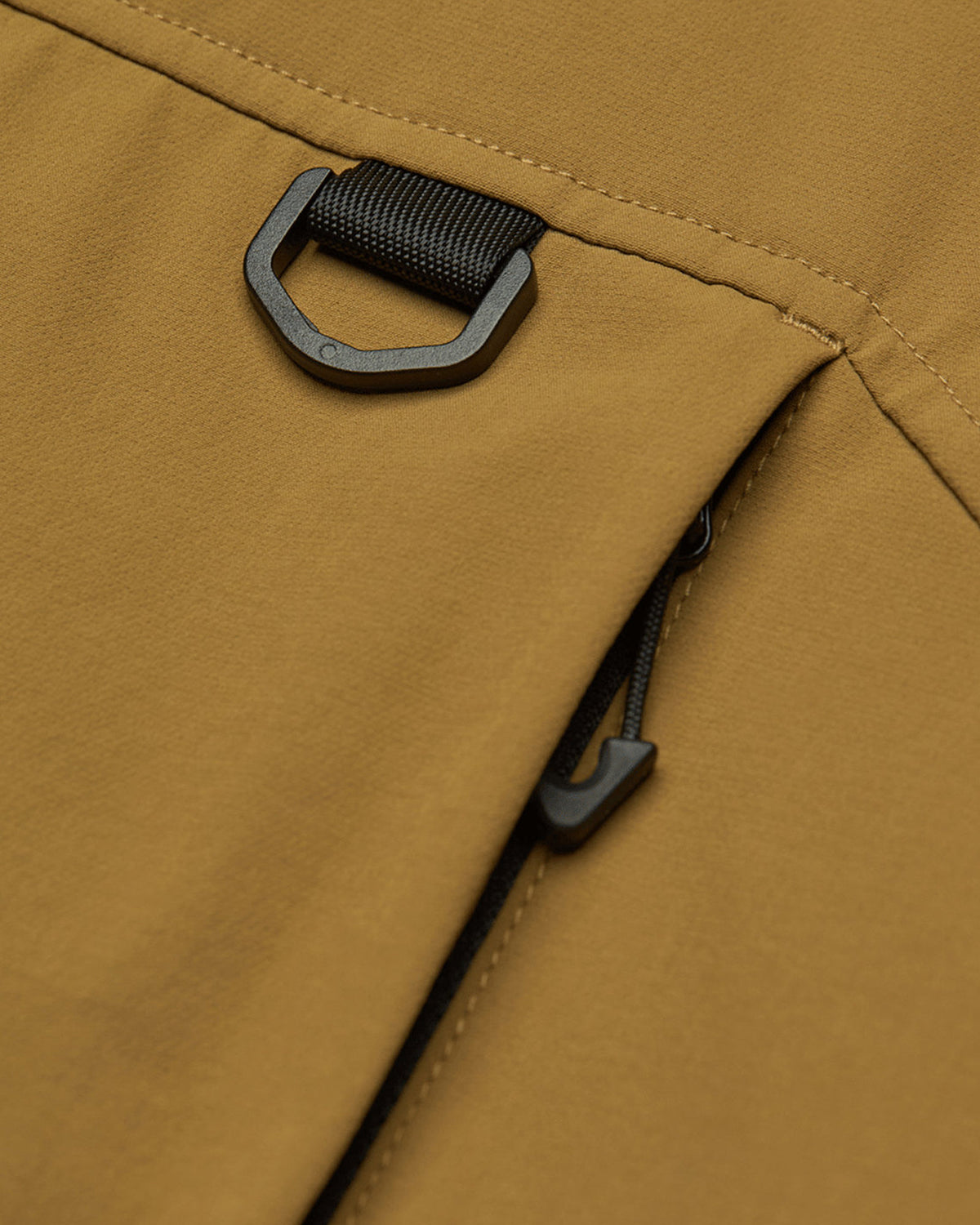 Vestes Element Mxe Revers Vest (N421) Toffee Mxe, gros plan sur la poche zippée et l'anneau d'accroche en D sur un vêtement marron ocre.