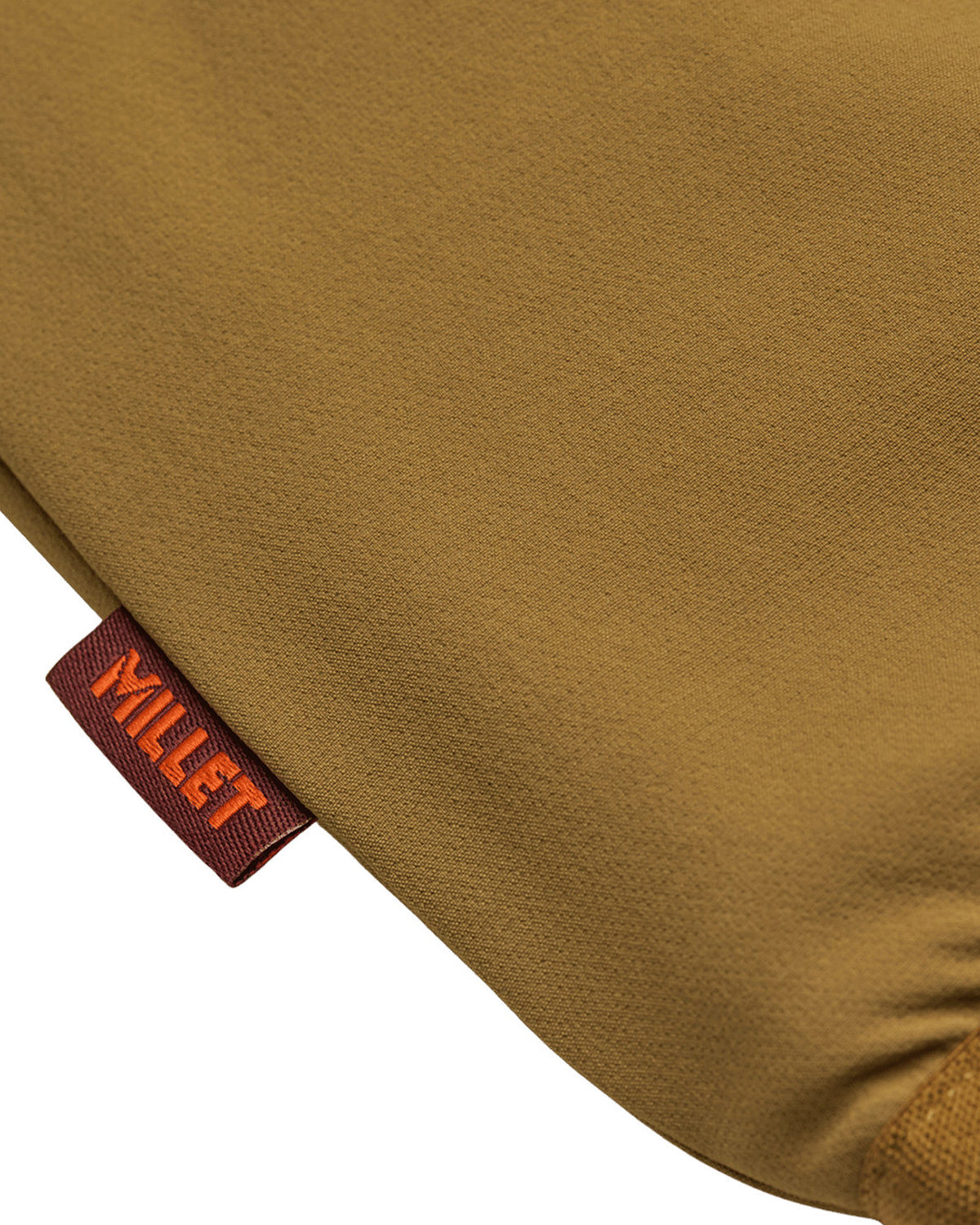 Vestes Element Mxe Revers Vest (N421) Toffee Mxe, gros plan sur une petite étiquette bordeaux avec le nom « MILLET » écrit en orange, insérée dans la couture d'un vêtement marron ocre.
