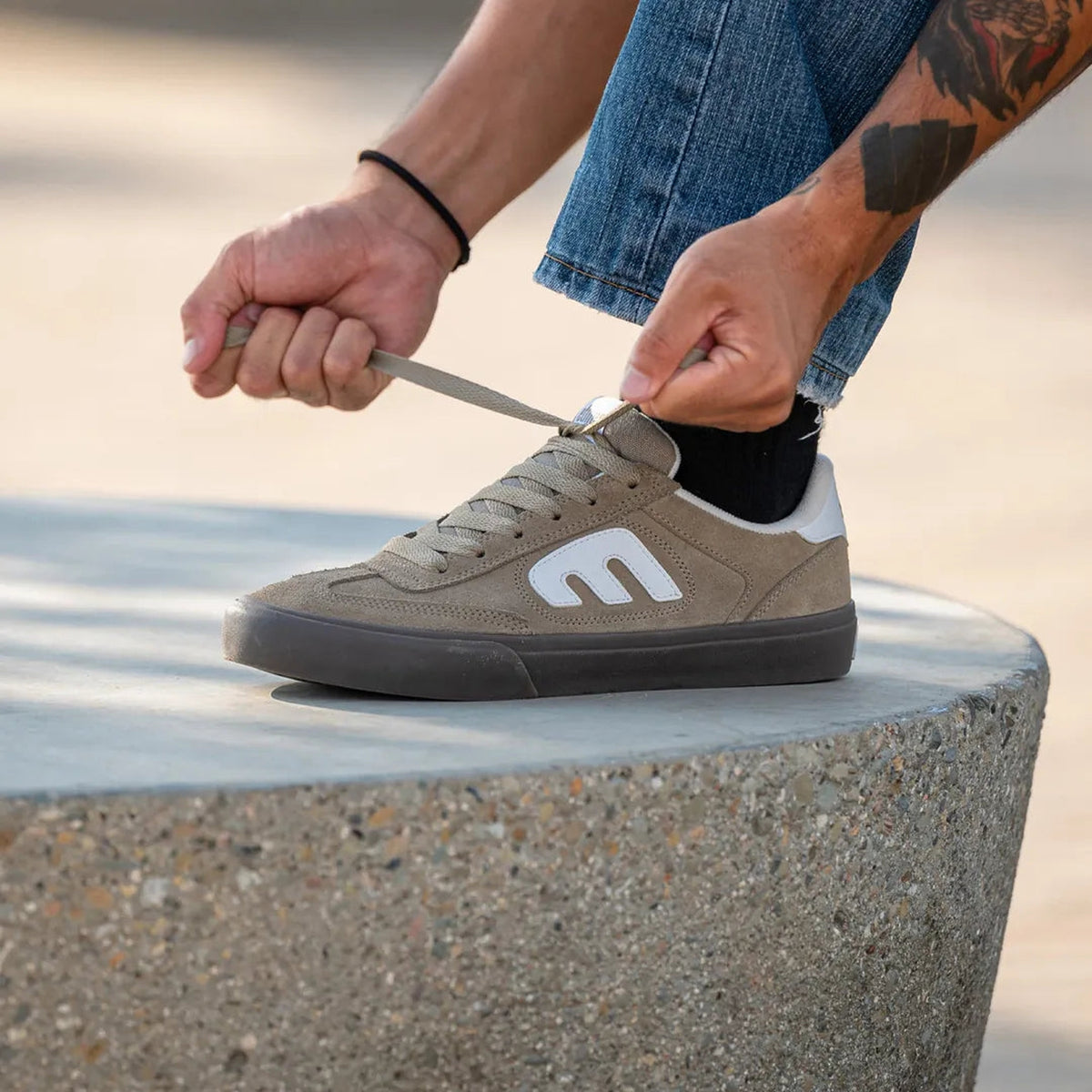 Chaussures de skateboard Etnies Etnies Locut Vulc Warm Grey Warm Grey, vue portée avec un jean en extérieur